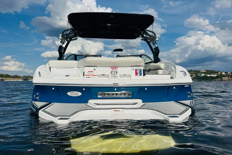 Slide: The Image of 2018 Cobalt CS23 Surf boat on water under a partly cloudy sky. - 6