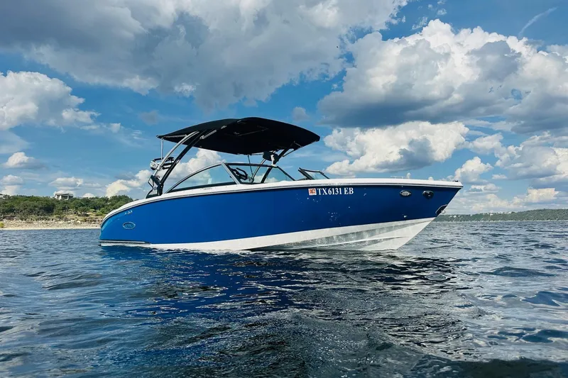 Slide: The Image of 2018 Cobalt CS23 Surf boat on water under blue sky with clouds. - 9
