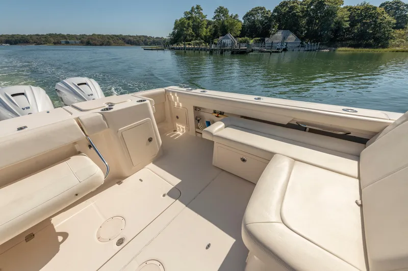 Slide: The Image of 2019 Grady-White Freedom 375 boat interior with seating, on a scenic lake. - 12