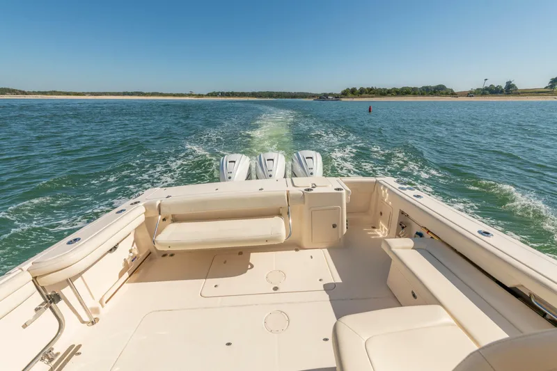 Slide: The Image of 2019 Grady-White Freedom 375 boat cruising on open water, showcasing spacious deck. - 18