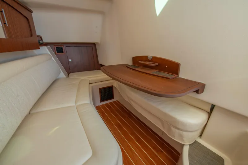 Slide: The Image of 2019 Grady-White Freedom 375 cabin interior with wooden table and cushioned seating. - 36