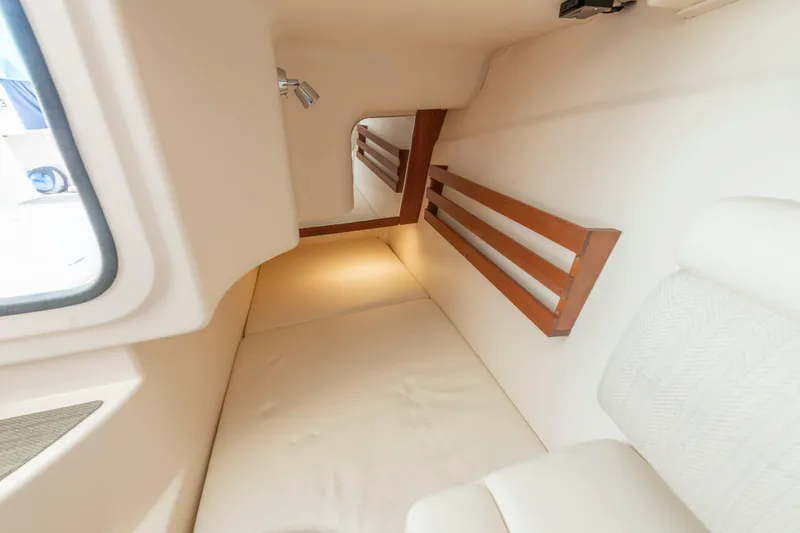 Slide: The Image of 2019 Grady-White Freedom 375 cabin interior with cozy bed and wooden accents. - 40