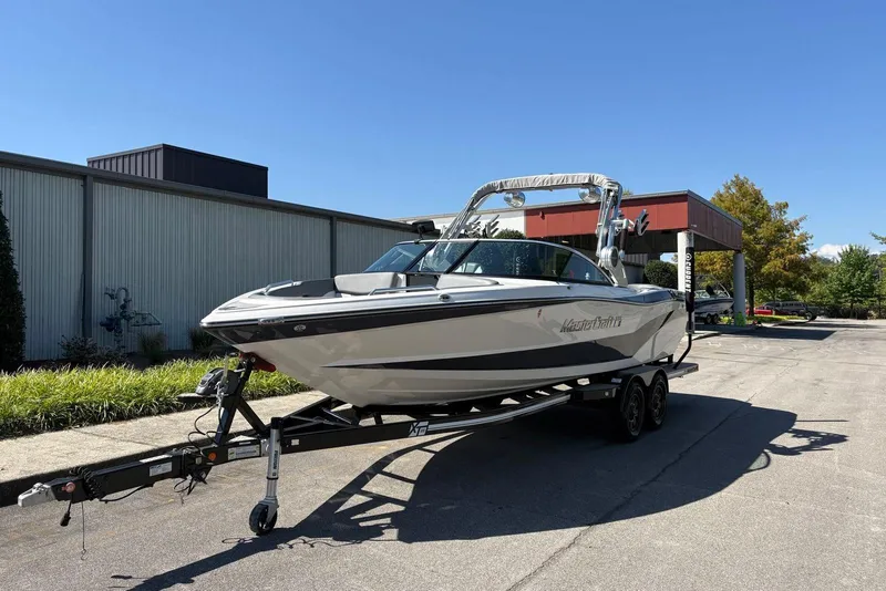 Slide: The Image of 2019 MasterCraft boat on trailer in sunny outdoor setting. - 2