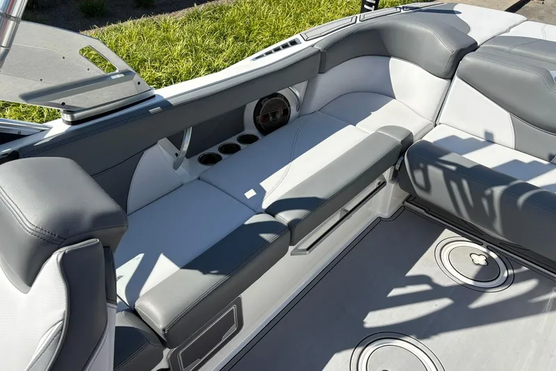 Slide: The Image of 2019 MasterCraft boat interior with gray and white seating, cup holders, and speaker. - 7