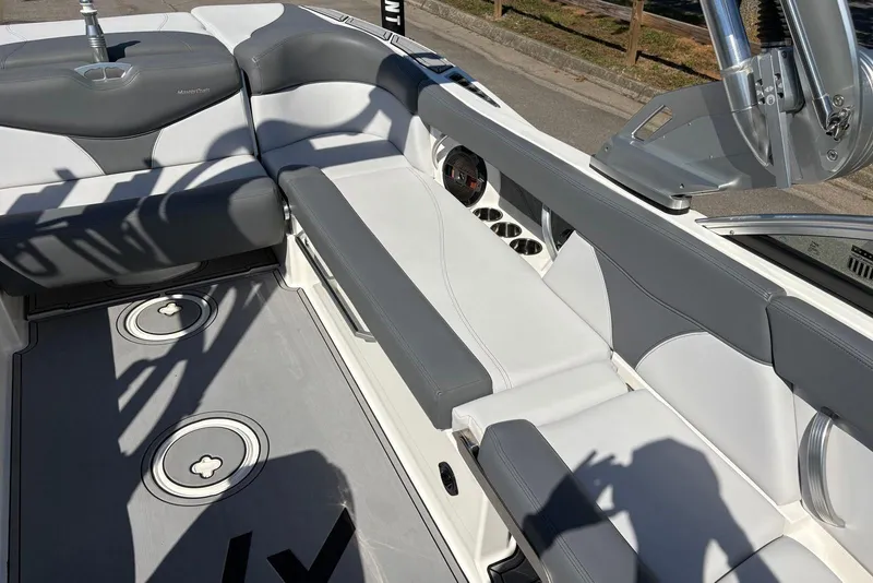 Slide: The Image of 2019 MasterCraft boat interior with gray and white seating, cup holders, and sleek design. - 8