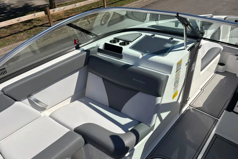 Slide: The Image of 2019 MasterCraft boat interior with gray and white seating, cup holders, and dashboard. - 9