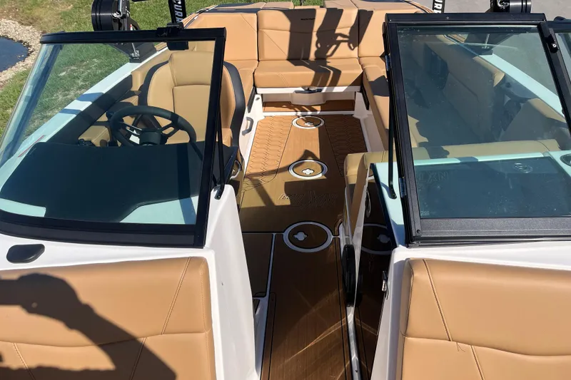 Slide: The Image of 2025 MasterCraft NXT23 boat interior with tan seating and sleek design. - 10