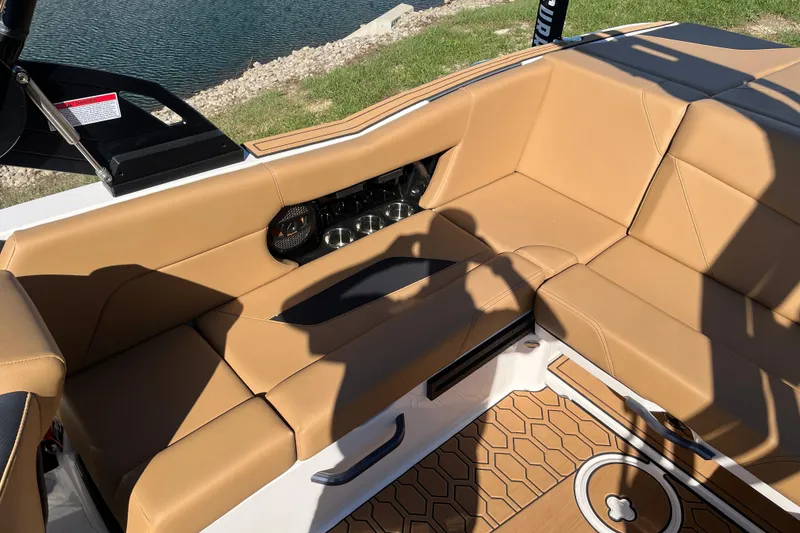 Slide: The Image of 2025 MasterCraft NXT23 boat interior with tan leather seating and cup holders. - 12