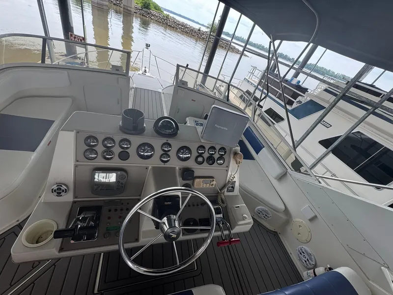 Slide: The Image of 1997 Carver 380 Santego yacht helm with gauges, steering wheel, and navigation equipment. - 11