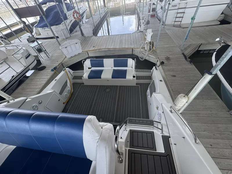 Slide: The Image of 1997 Carver 380 Santego boat interior with blue and white seating at a marina dock. - 12