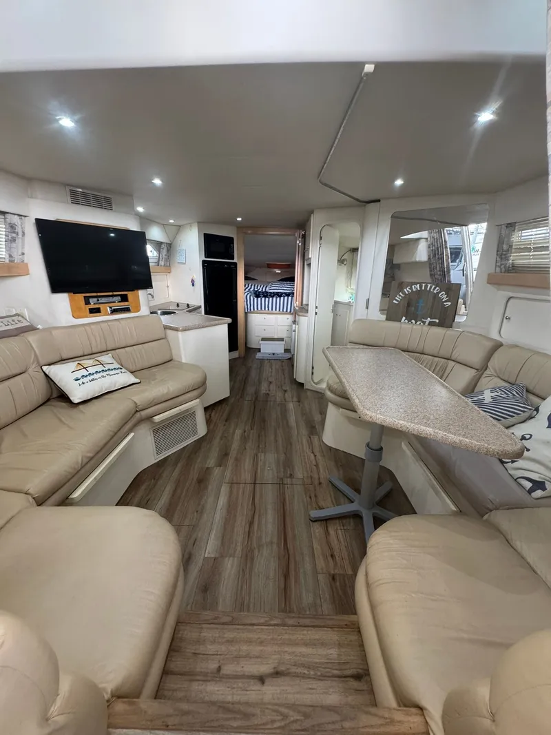 Slide: The Image of Interior of a 1997 Carver 380 Santego yacht with beige seating and wood flooring. - 13
