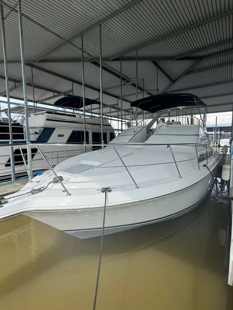 Slide: The Image of 1997 Carver 380 Santego yacht docked under a covered marina. - 2