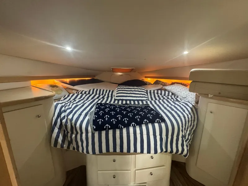 Slide: The Image of Cozy cabin interior of 1997 Carver 380 Santego with striped bedding and ambient lighting. - 23