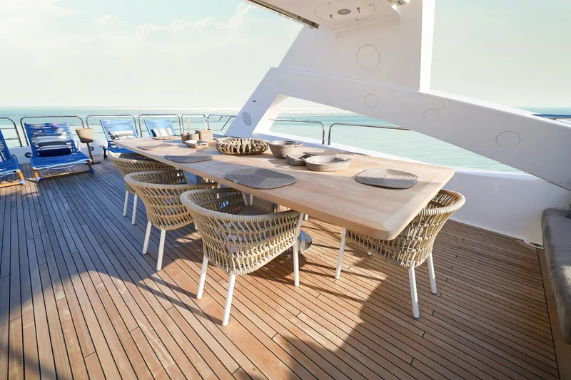 Slide: The Image of Luxurious Sunseeker 131 yacht deck with elegant dining setup, wicker chairs, and ocean view. - 48