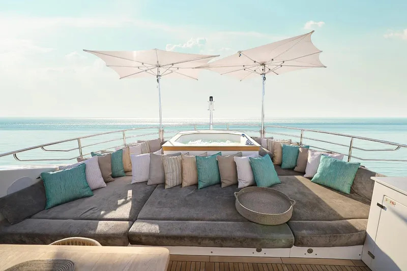 Slide: The Image of Luxurious Sunseeker 131 yacht deck with plush seating, cushions, and parasols, overlooking serene ocean. - 50