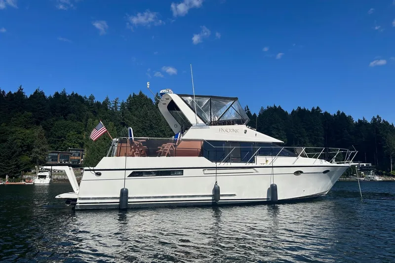 The Image of 1988 Ocean Alexander 42' yacht on a serene lake with forested background. - 0