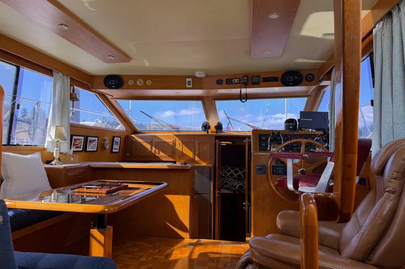 Slide: The Image of 1988 Ocean Alexander 42' yacht interior with covered seating and marina view. - 12