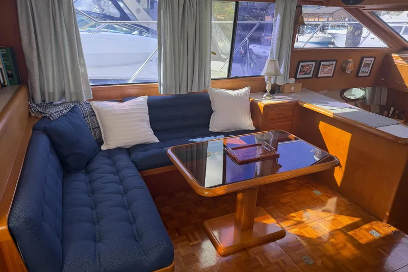 Slide: The Image of 1988 Ocean Alexander 42' yacht interior with wooden helm, dining area, and nautical decor. - 18