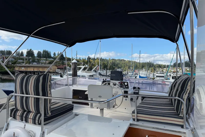 Slide: The Image of 1988 Ocean Alexander 42' yacht "Fin & Tonic" with black canopy and striped cushions. - 6