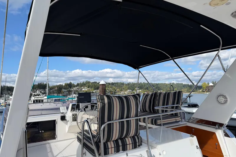 Slide: The Image of 1988 Ocean Alexander 42' yacht interior with marina view, featuring striped seating and helm. - 9