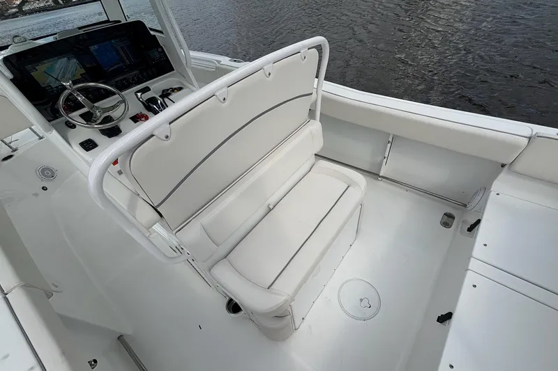 Slide: The Image of 2024 Sea Hunt Ultra 255 SE boat dashboard with navigation screens on a calm waterway. - 11