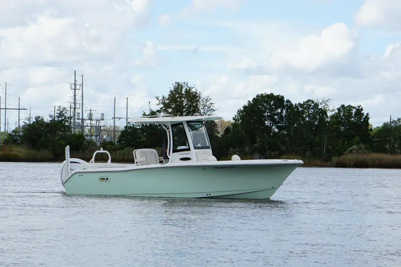 Slide: The Image of 2024 Sea Hunt Ultra 255 SE boat on calm water, side view. - 15