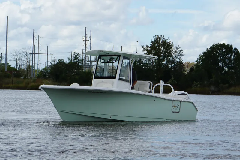 Slide: The Image of 2024 Sea Hunt Ultra 255 SE boat on calm water, showcasing sleek design and modern features. - 2