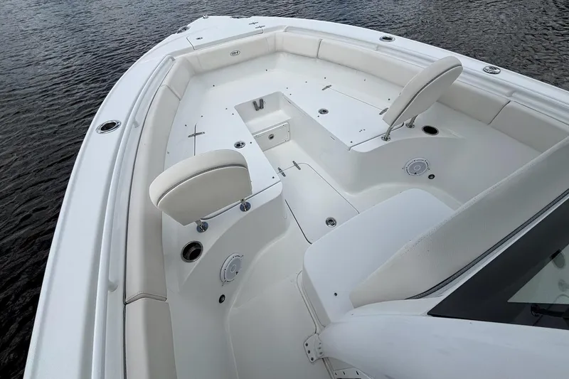 Slide: The Image of 2024 Sea Hunt Ultra 255 SE boat on calm water, featuring a powerful engine. - 20