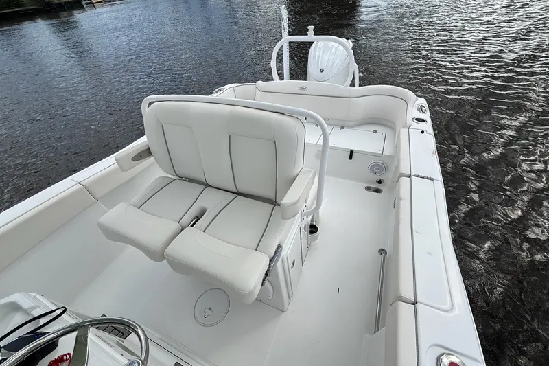 Slide: The Image of 2024 Sea Hunt Ultra 255 SE boat interior with seating and storage, on calm water. - 21