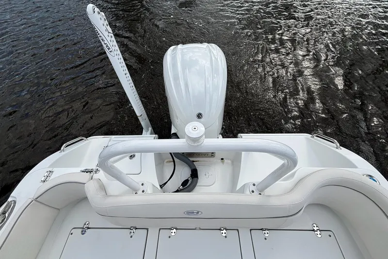 Slide: The Image of 2024 Sea Hunt Ultra 255 SE boat stern view with motor and water backdrop. - 23