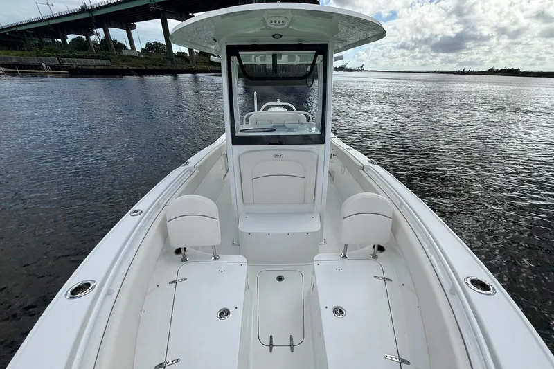 Slide: The Image of 2024 Sea Hunt Ultra 255 SE boat on calm water under cloudy sky. - 24