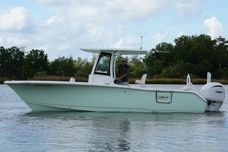 Slide: The Image of 2024 Sea Hunt Ultra 255 SE boat on calm water, side view. - 26