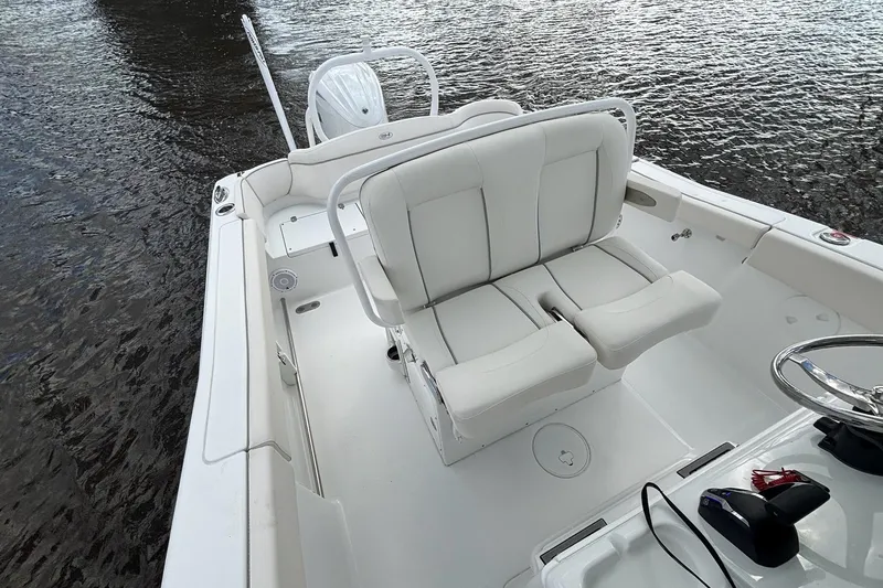 Slide: The Image of 2024 Sea Hunt Ultra 255 SE boat interior with white seating at a marina. - 8