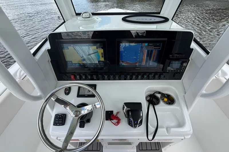 Slide: The Image of 2024 Sea Hunt Ultra 255 SE boat interior with white seating and steering wheel. - 9