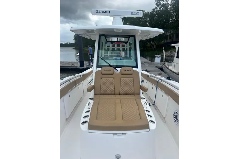 Slide: The Image of 2023 Caymas 341 CC boat with tan seating and Garmin equipment at a dock. - 12