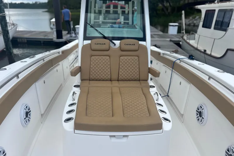Slide: The Image of 2023 Caymas 341 CC boat with tan seating and sleek design at a dock. - 13