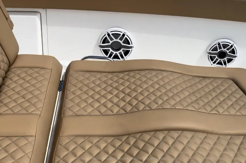 Slide: The Image of 2023 Caymas 341 CC boat with tan quilted seats and marine speakers. - 16
