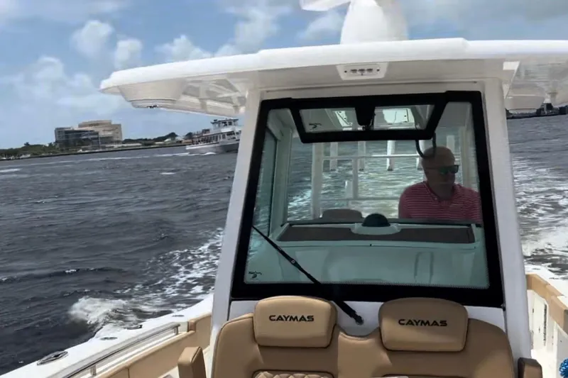 Slide: The Image of 2023 Caymas 341 CC boat cruising on water with a person at the helm. - 17