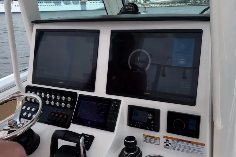 Slide: The Image of 2023 Caymas 341 CC boat dashboard with advanced navigation screens and controls. - 21