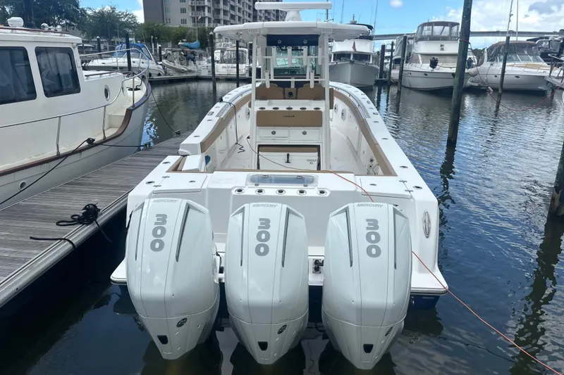 Slide: The Image of 2023 Caymas 341 CC boat with triple Mercury 300 engines docked at marina. - 5