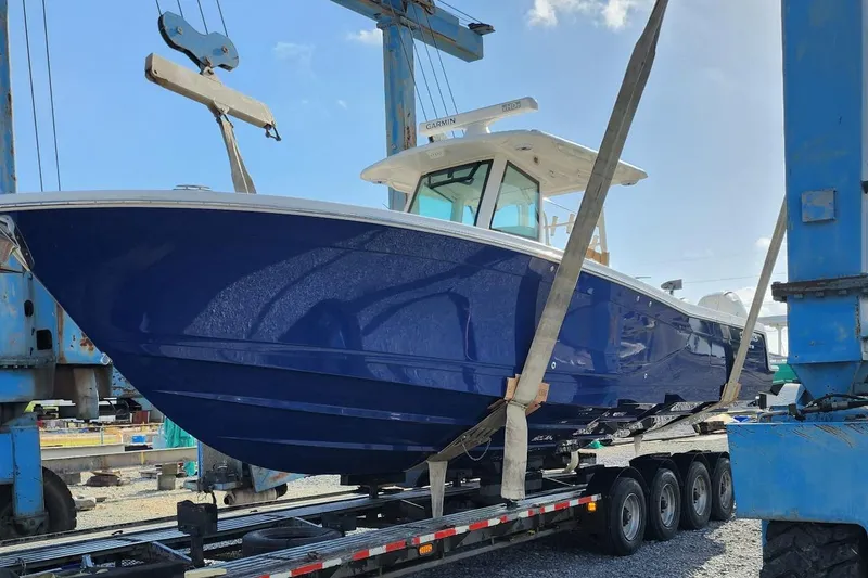 Slide: The Image of 2023 Caymas 341 CC boat in blue, secured on a trailer for transport. - 6