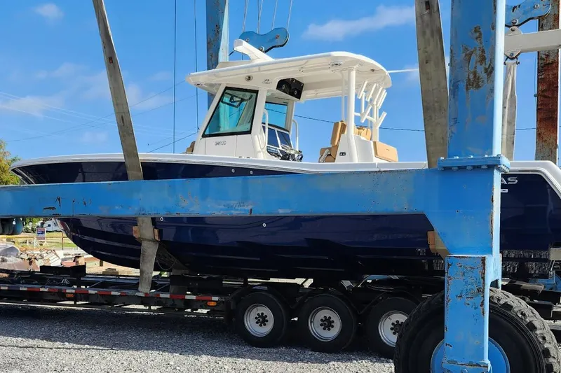 Slide: The Image of 2023 Caymas 341 CC boat on trailer, blue hull, outdoor setting. - 7