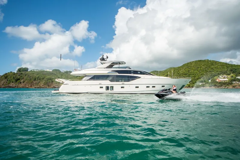 The Image of 2018 Sanlorenzo SL86 yacht cruising with jet ski nearby, under clear skies. - 0
