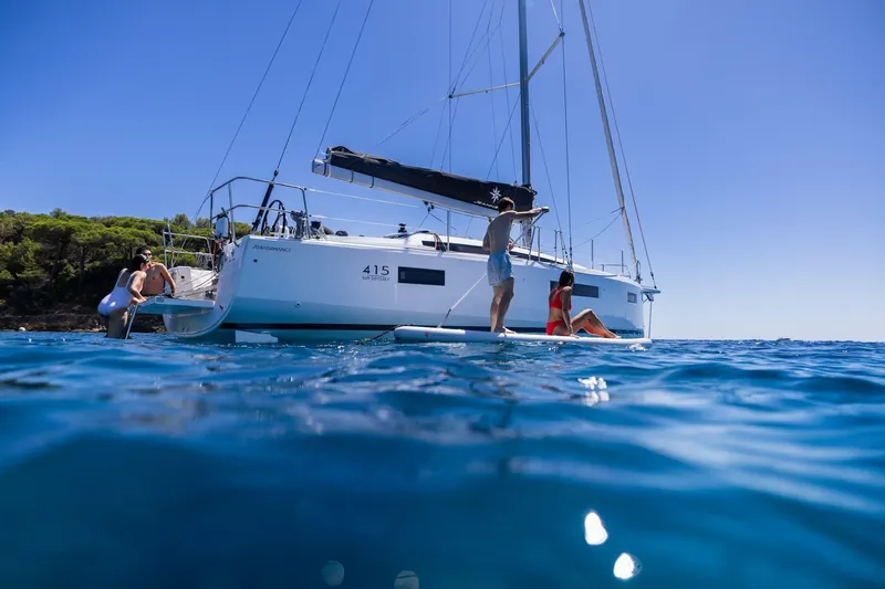 Slide: The Image of 2026 Jeanneau Sun Odyssey 415 sailboat with people enjoying water activities. - 2