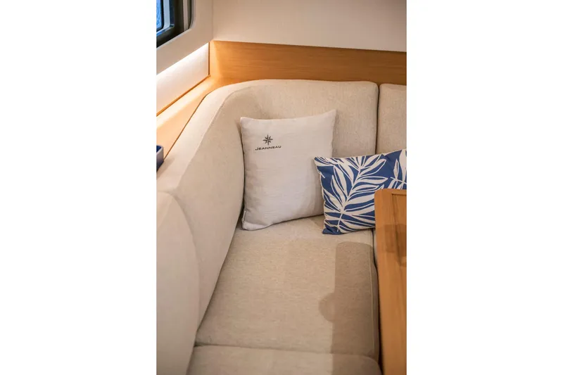 Slide: The Image of Interior of 2026 Jeanneau Sun Odyssey 415 with cozy beige seating and decorative pillows. - 23