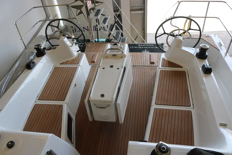 Slide: The Image of 2026 Jeanneau Sun Odyssey 415 yacht cockpit with dual steering wheels and teak flooring. - 16