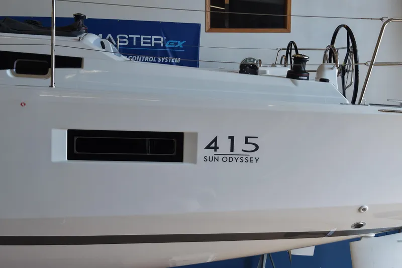 Slide: The Image of 2026 Jeanneau Sun Odyssey 415 yacht side view in a showroom setting. - 3