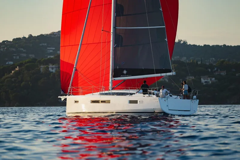 Slide: The Image of 2026 Jeanneau Sun Odyssey 415 sailing with vibrant red sails on calm waters. - 8