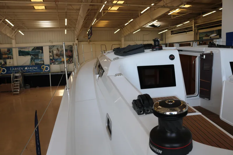 Slide: The Image of 2026 Jeanneau Sun Odyssey 415 sailboat in a marina showroom, showcasing sleek design. - 15