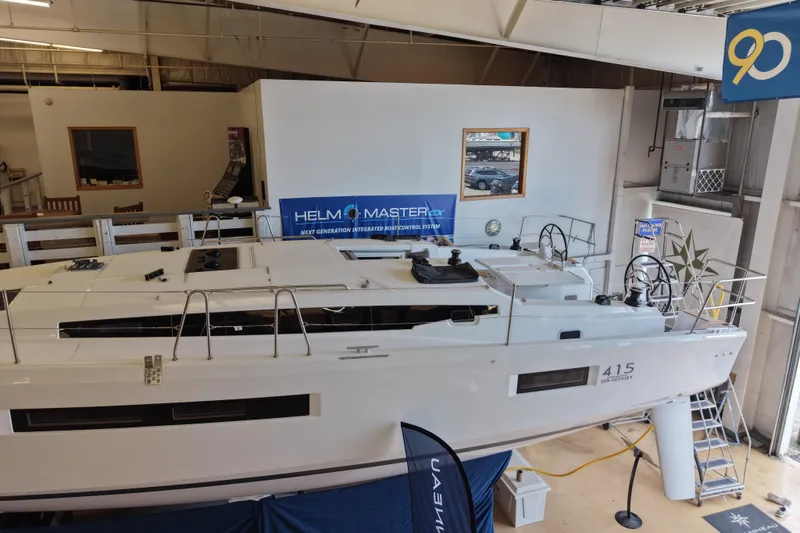 Slide: The Image of 2026 Jeanneau Sun Odyssey 415 sailboat displayed indoors, showcasing sleek design and advanced features. - 2